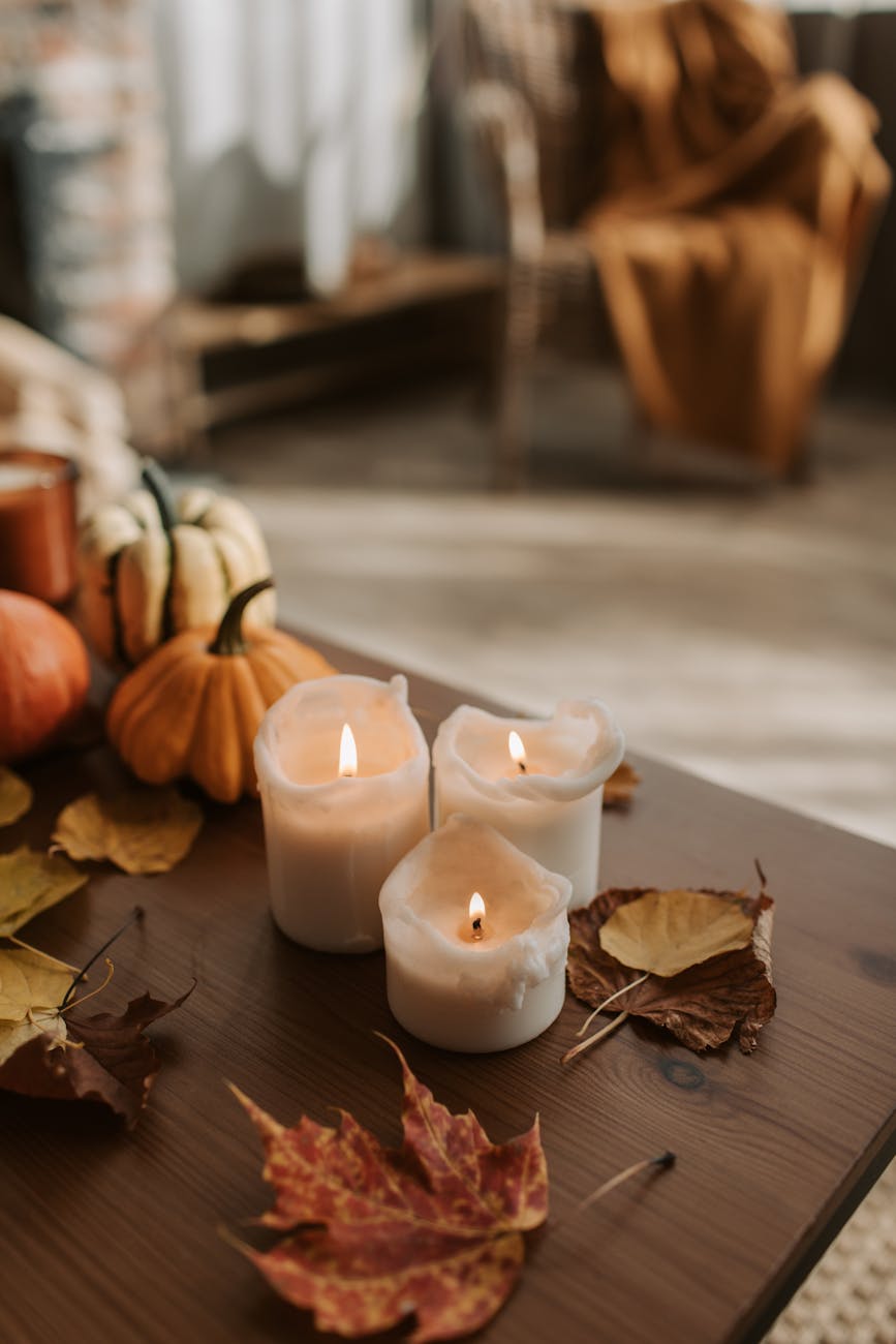 lit candles and dried leaves on the table